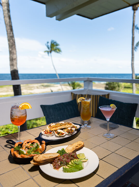 Oceanfront patio dining with cocktails and seafood at Sea Watch on the Ocean