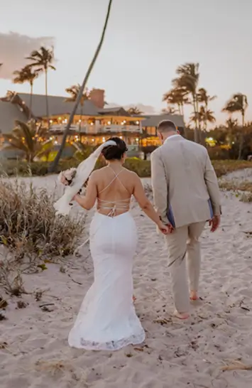Bride and groom walking along the beach at Sea Watch on the Ocean